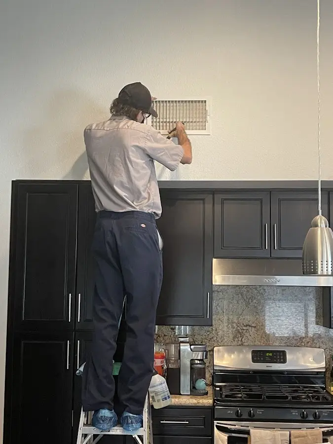 Technician inspecting an air vent during HVAC service in Martins Ferry